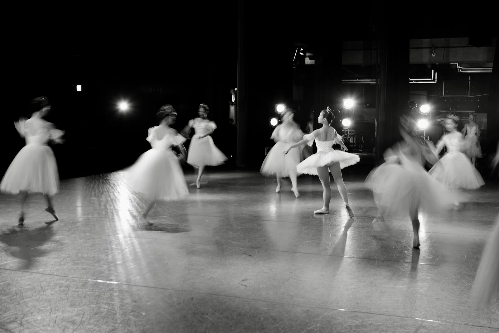 Dancers performing on a stage under spotlights