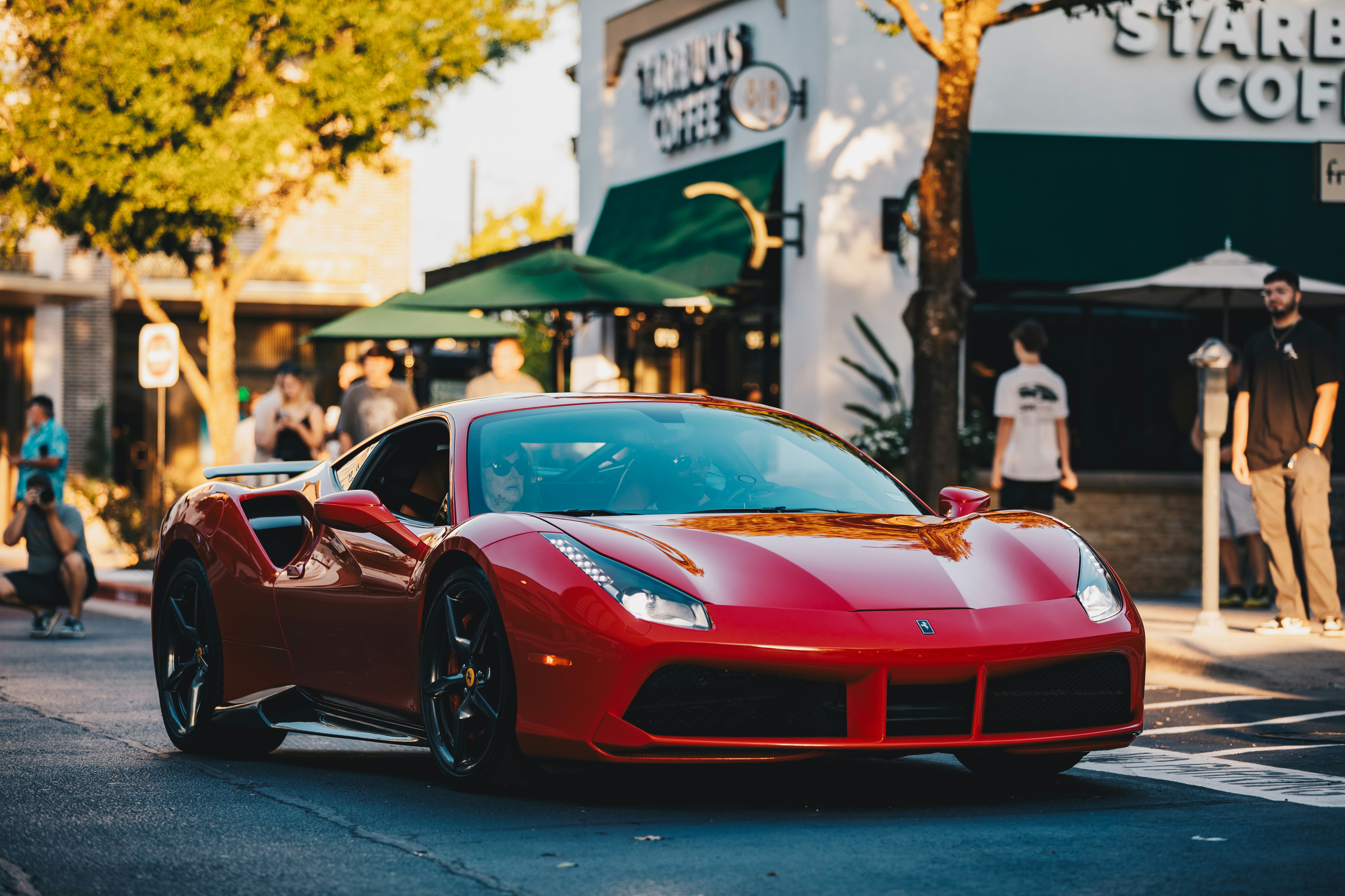 Red sports car driving on a city street
