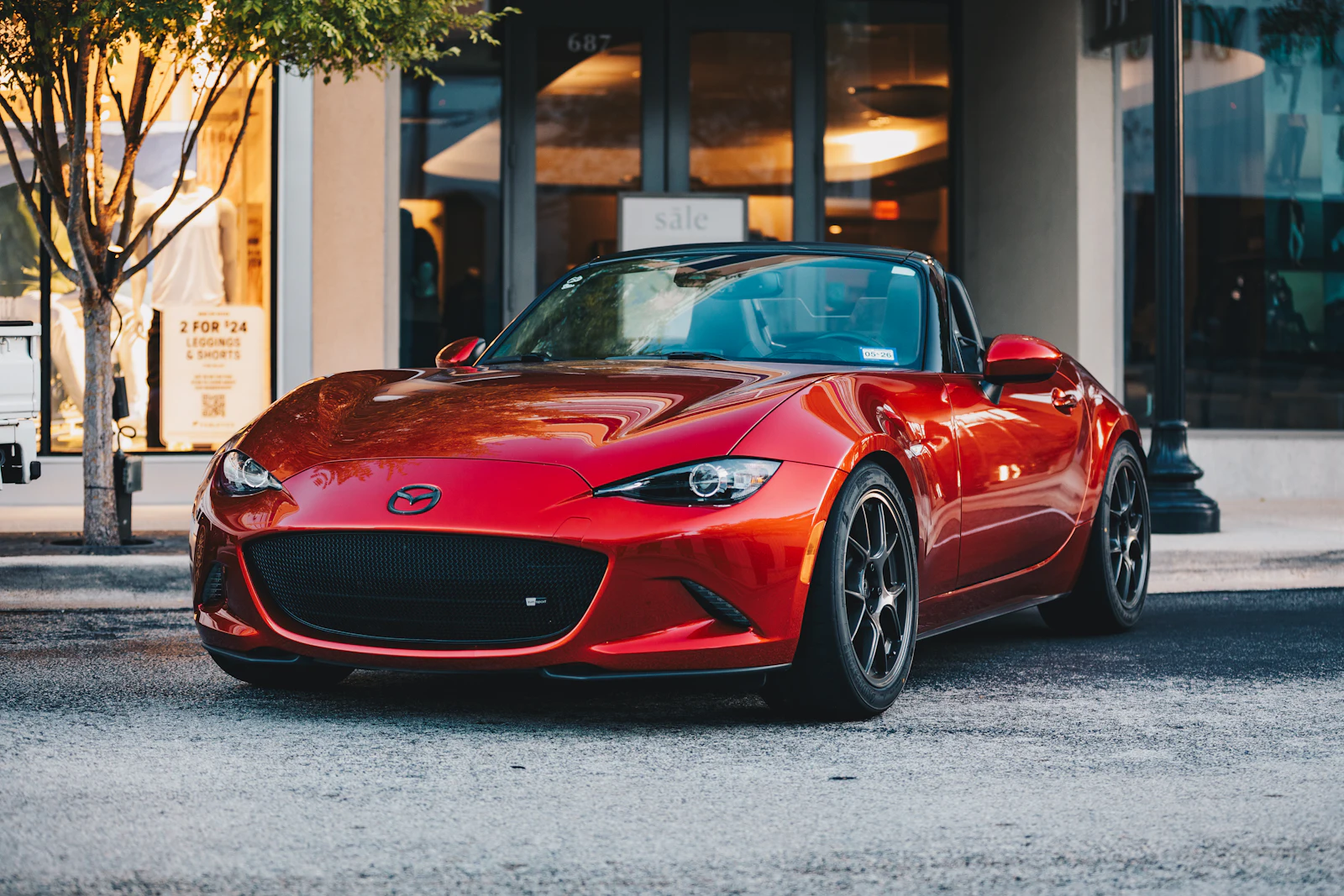 Red MX-5 roadster parked on a city street