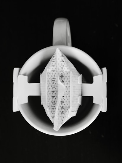 A single-serve coffee drip bag on a white mug.