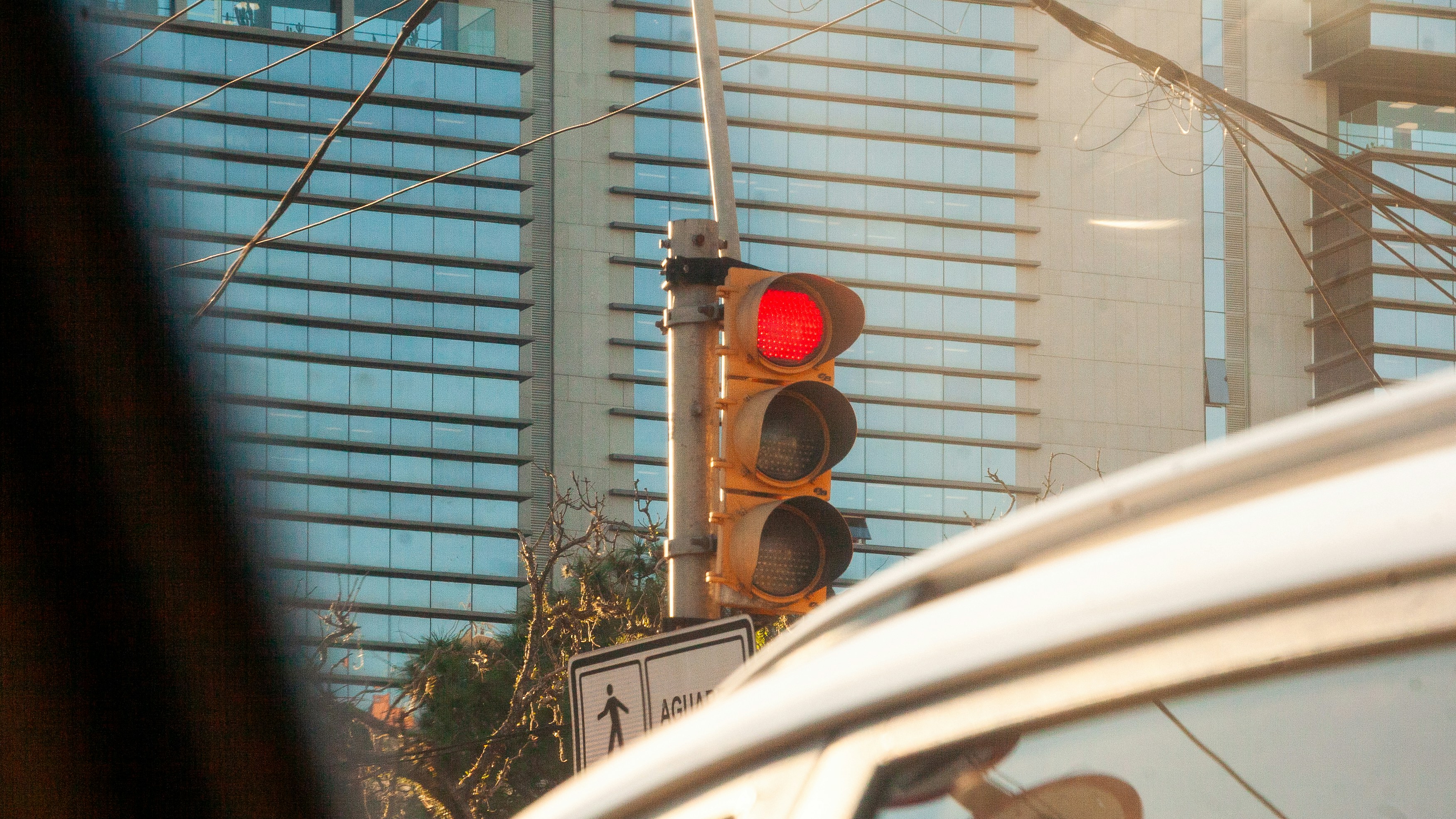 Red traffic light against a modern building