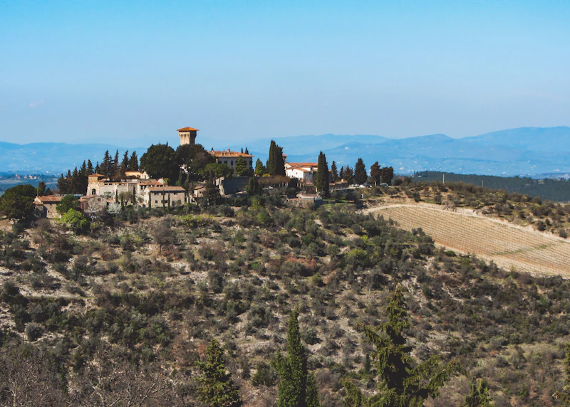 Tuscan villa surrounded by cypress trees and rolling green hills