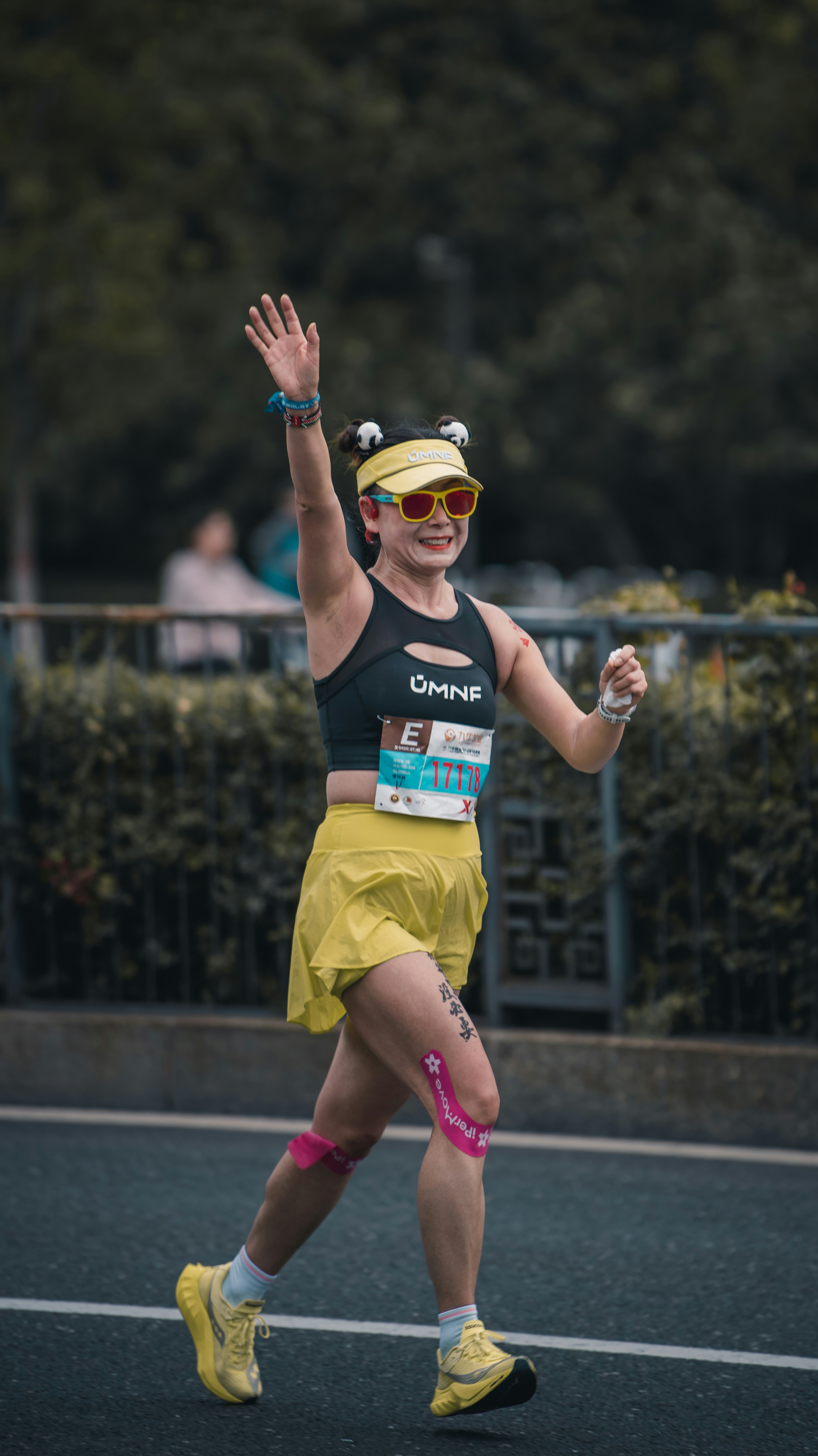 A woman running and waving during a race.