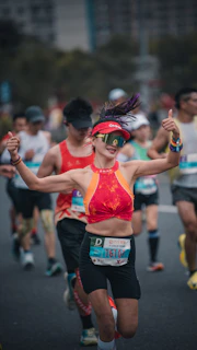 Woman running marathon, giving thumbs up