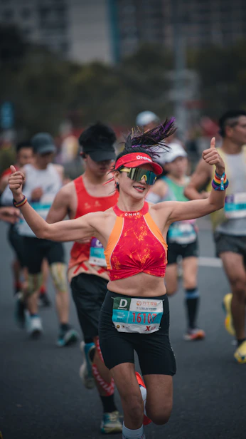 Woman running marathon, giving thumbs up