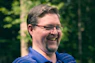 Man with glasses smiling outdoors