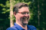 Man with glasses smiling outdoors