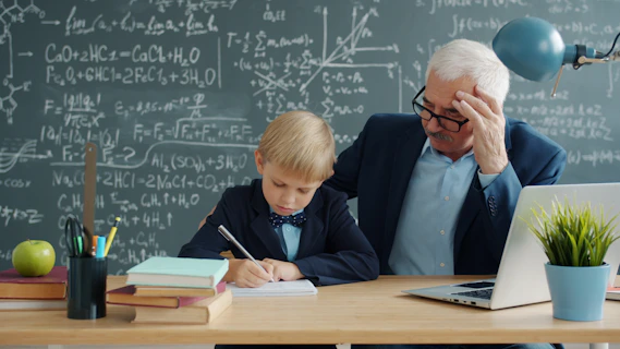 Teacher helping young student with math problems at desk.