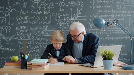 Elderly teacher helps young student with math.