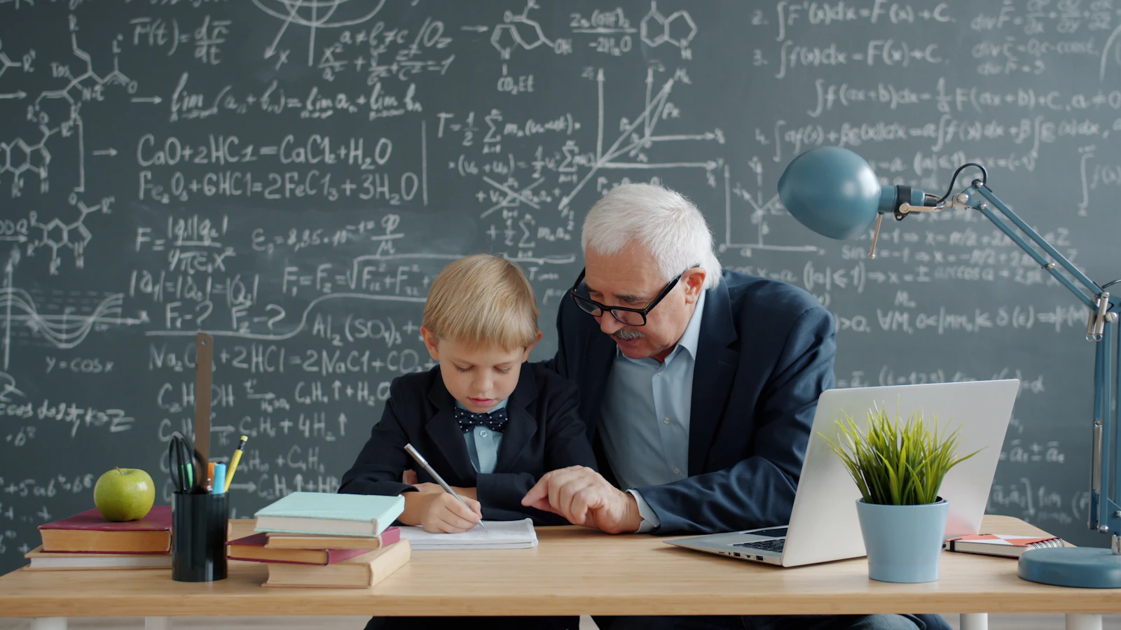 An elderly teacher helping a young student, a picture of mentorship and investment in someone else