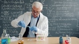Scientist in lab coat conducts experiment with test tubes.