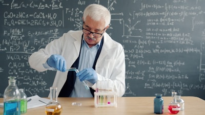 Scientist in lab coat conducts experiment with test tubes.