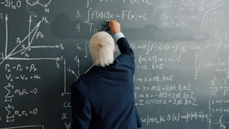 Professor writing mathematical formulas on a blackboard.