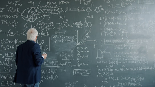 Professor writing complex formulas on a chalkboard