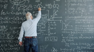 A professor writing complex formulas on a blackboard.