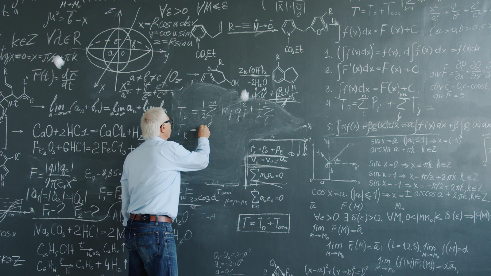 Faculty member writing equations across a large blackboard