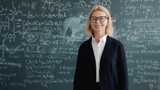 Woman smiling in front of blackboard with math equations