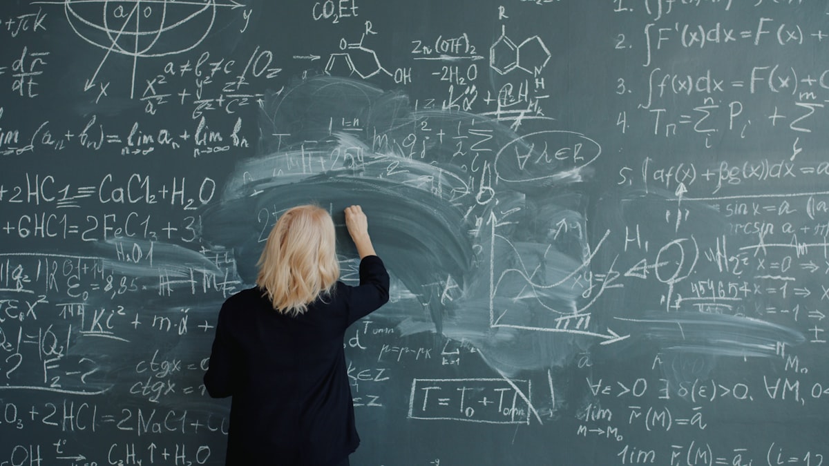 Math teacher writing complex equations on a chalkboard while using AI tools for math teachers in 2026