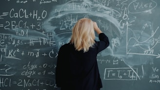 Woman writing complex formulas on a blackboard