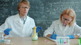 Scientists in lab coats conduct experiment with colorful liquids.