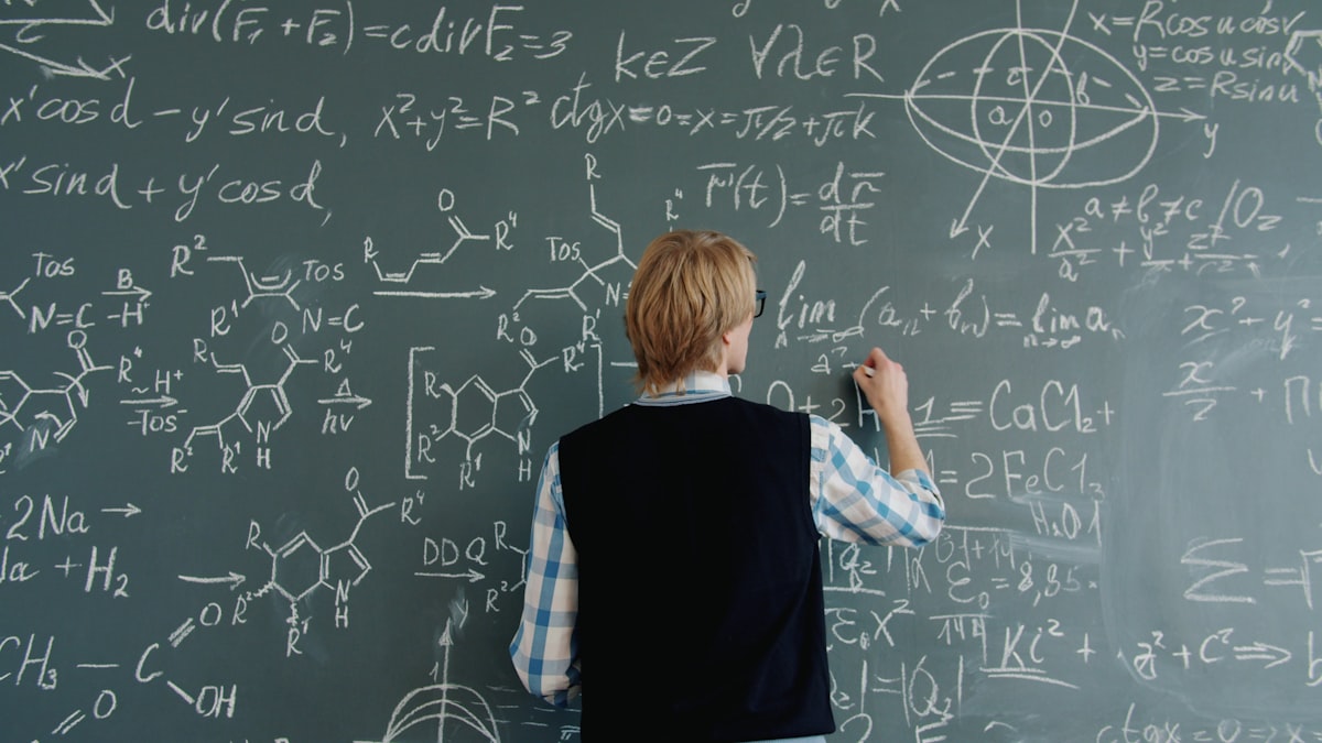 Teacher writing math equations on a chalkboard while planning lessons with AI tools for STEM teachers