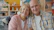 Elderly couple smiling together on a couch.