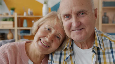 Elderly couple smiling together in their home, happy and connected
