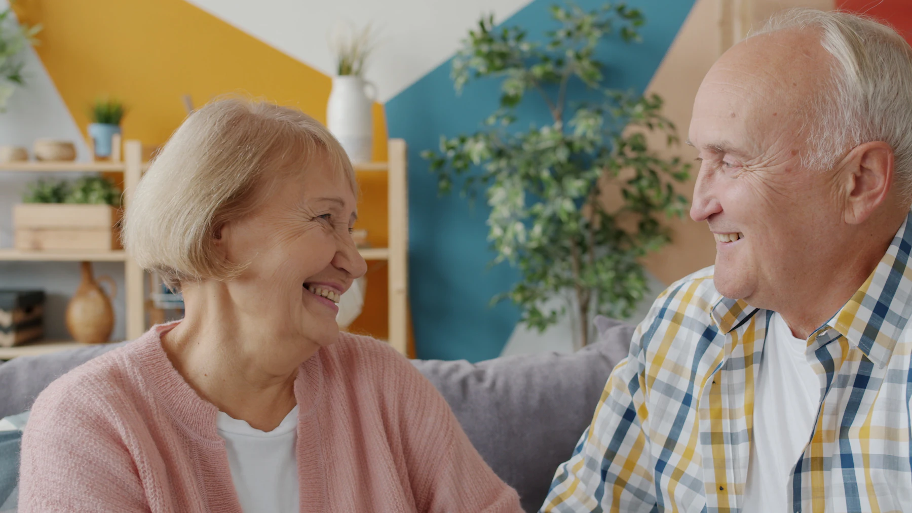 Older couple smiling together on a sofa at home