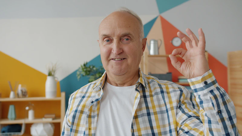 elderly man giving a friendly okay hand gesture