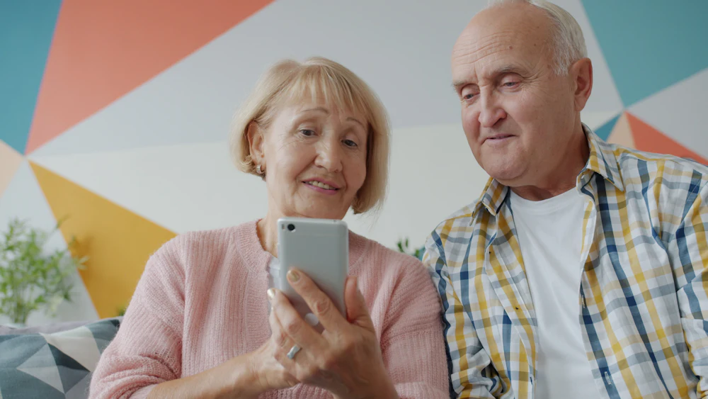An older couple looking at a phone together