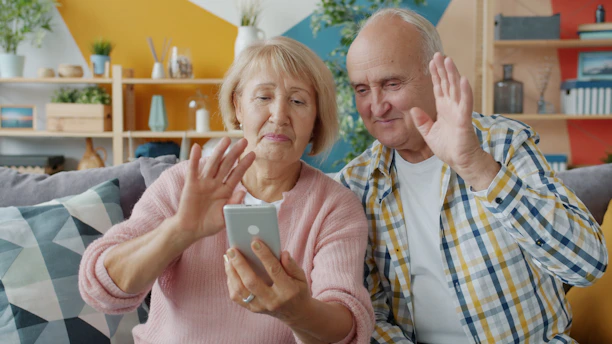 Elderly couple waving at smartphone screen