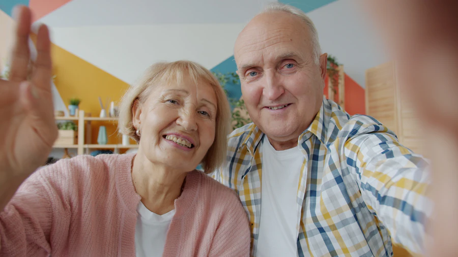 Older couple smiling and waving at family on a video call