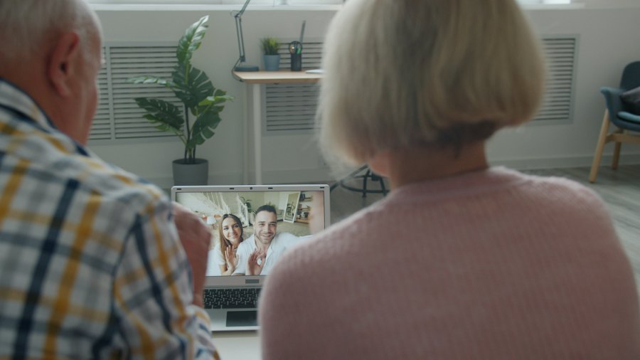 An older couple video calling their family from a laptop at home