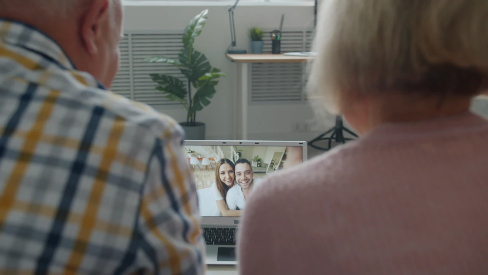 A senior couple joyfully connecting with family through a live video call