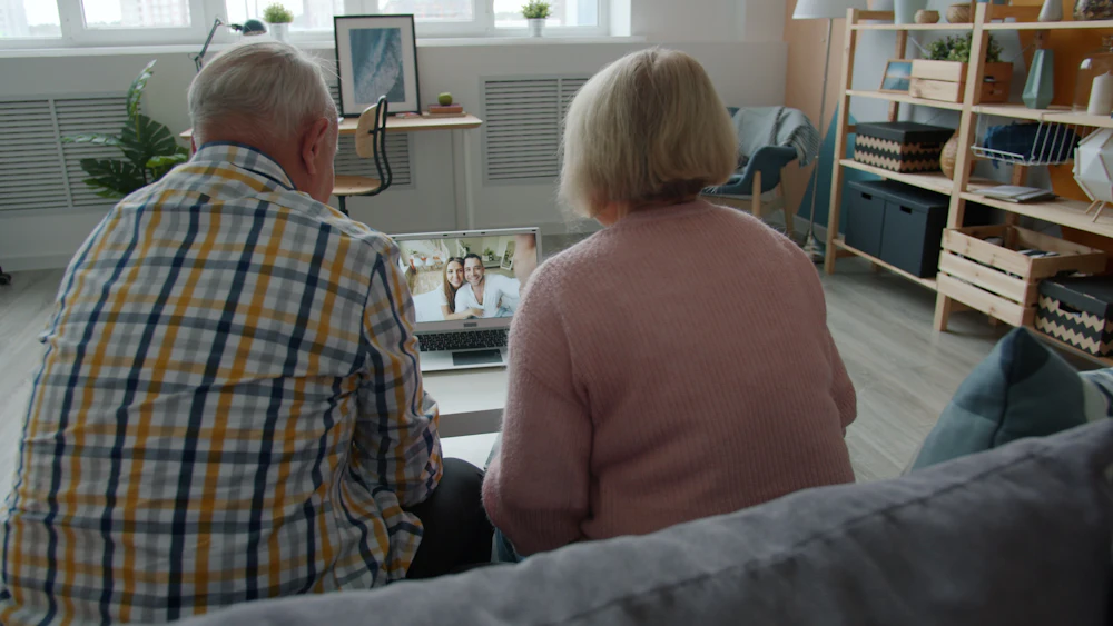 An older couple looking at a laptop together at home