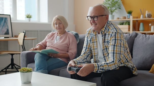 Elderly couple playing video games on the couch