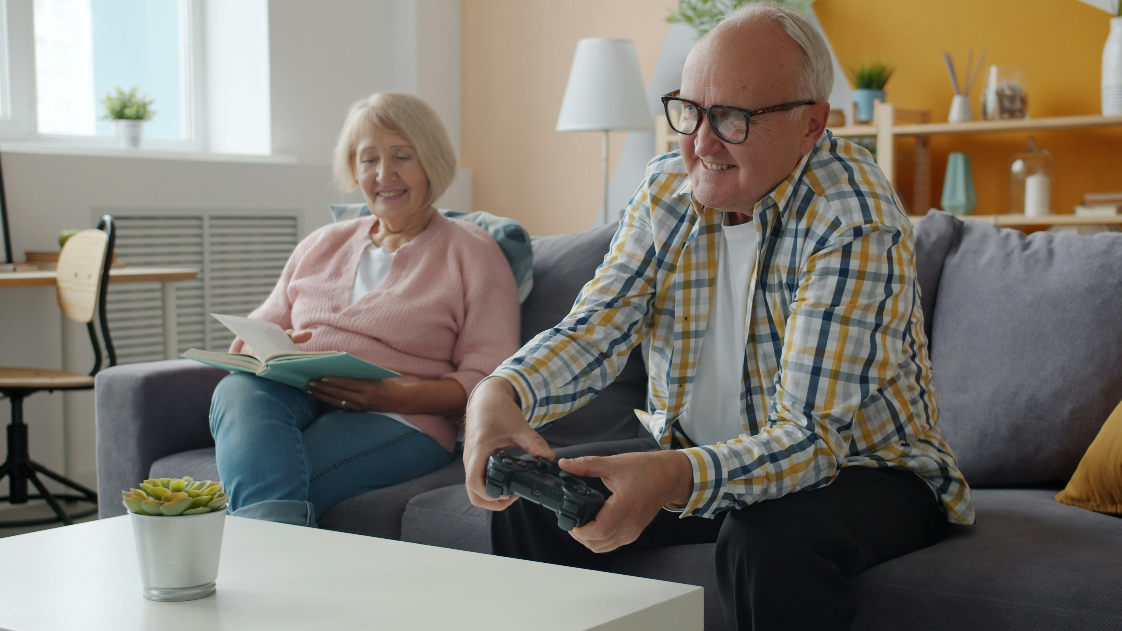 Elderly couple playing video games on the couch