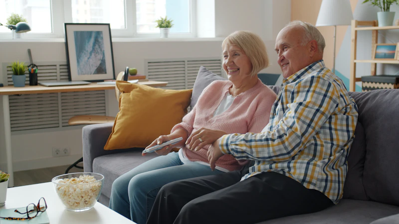 Elderly couple watching TV on a sofa