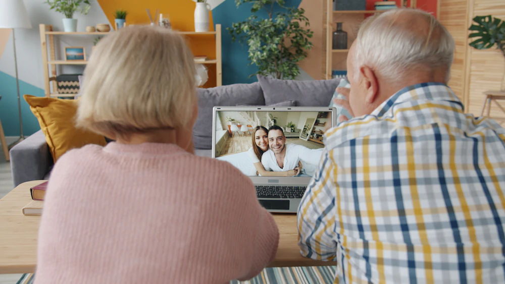 An older couple on a video call with younger family members