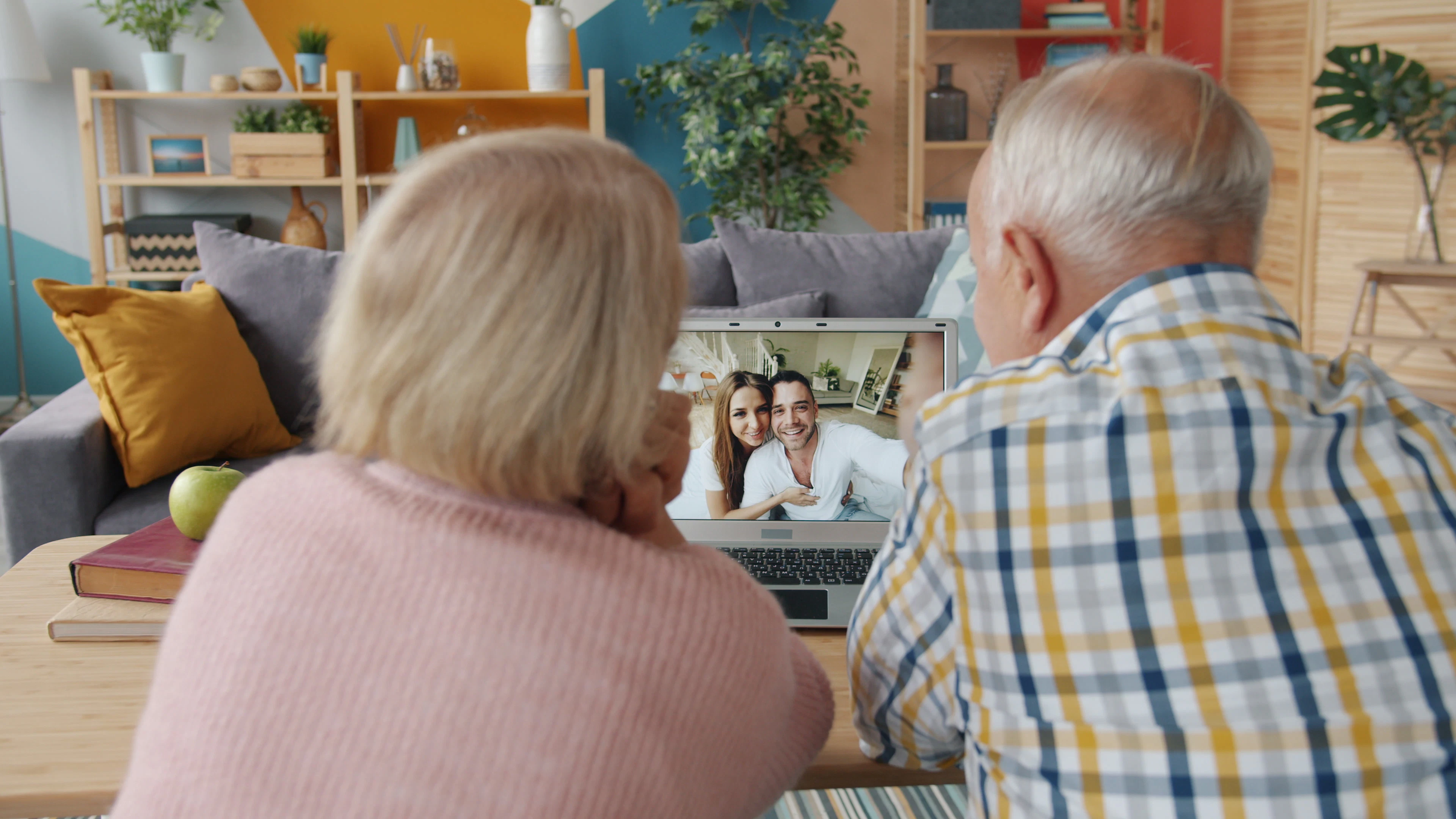 An older couple on a video call with their family