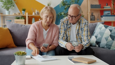 Elderly couple looking at bills and phone