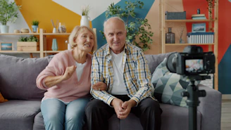 Elderly couple records themselves on a camera.