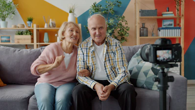 Elderly couple records themselves on a camera.