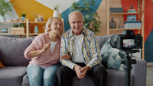 Elderly couple records themselves on a camera.