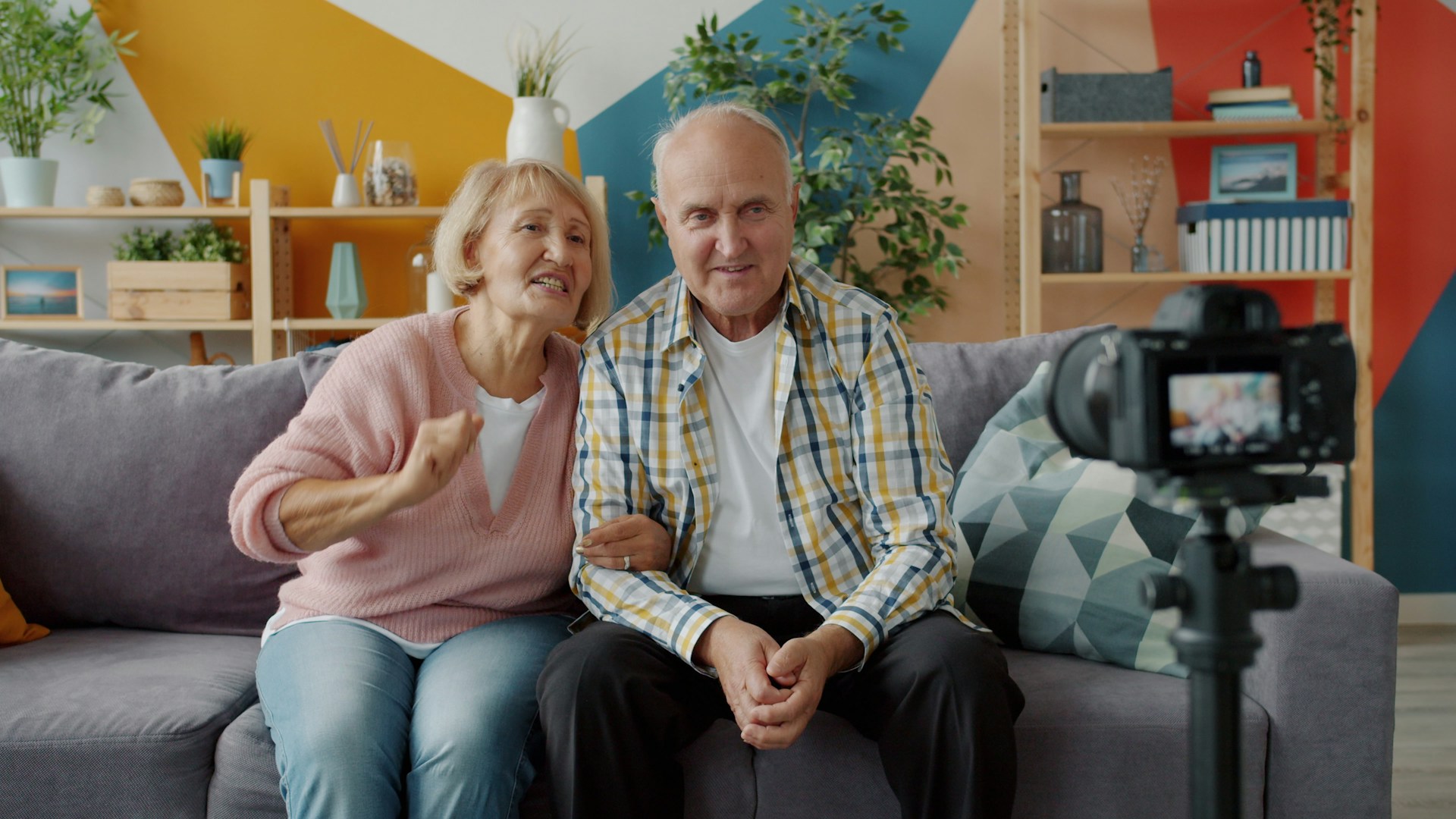 Elderly couple records themselves on a camera.