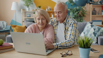 Pareja de ancianos mirando juntos una computadora portátil