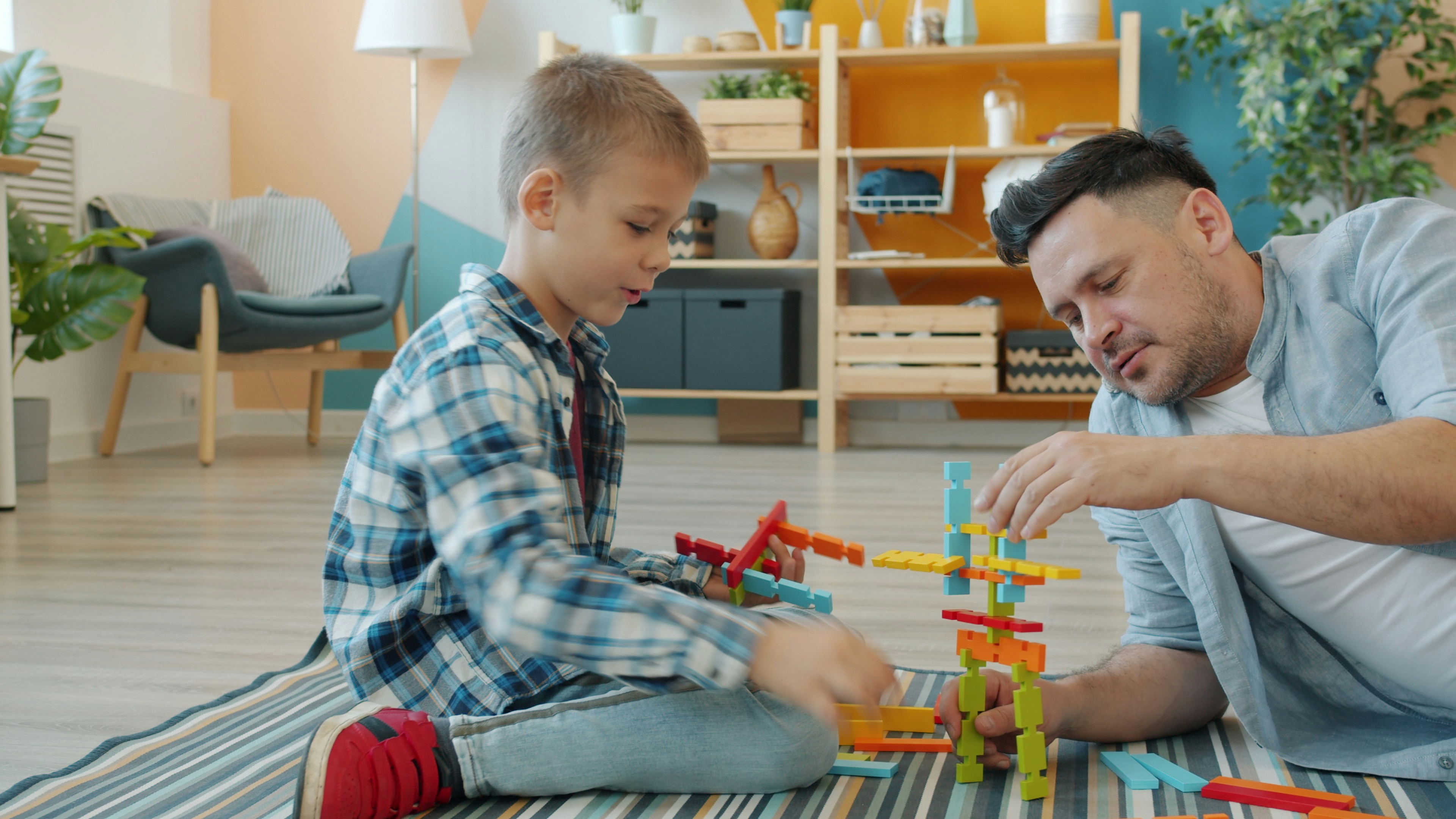 Father and son building with colorful blocks together