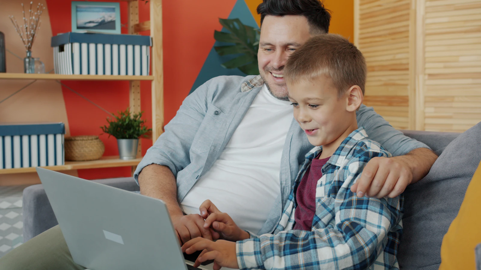 Parent and child using a laptop together at home