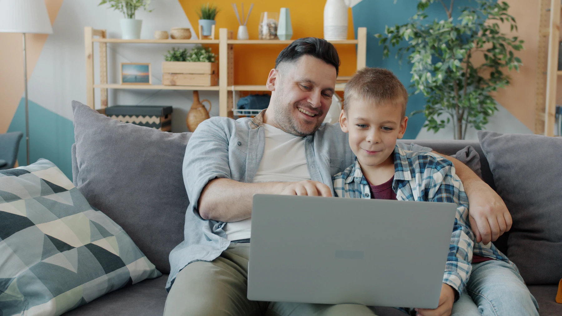 Father and son using a laptop together at home