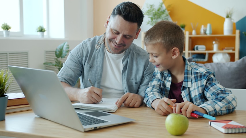 Father and son studying together at a desk.